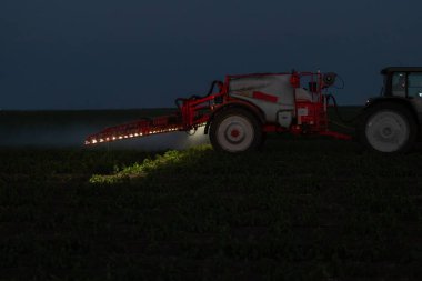 Traktör baharda sebze tarlasına böcek ilacı püskürtüyor.