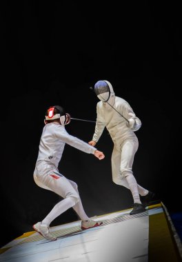 Eskrim yarışmasında dövüş. Profesyonel spor sahasında iki eskrim sporcusu kavga ediyor