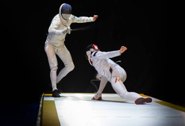 Eskrim yarışmasında dövüş. Profesyonel spor sahasında iki eskrim sporcusu kavga ediyor