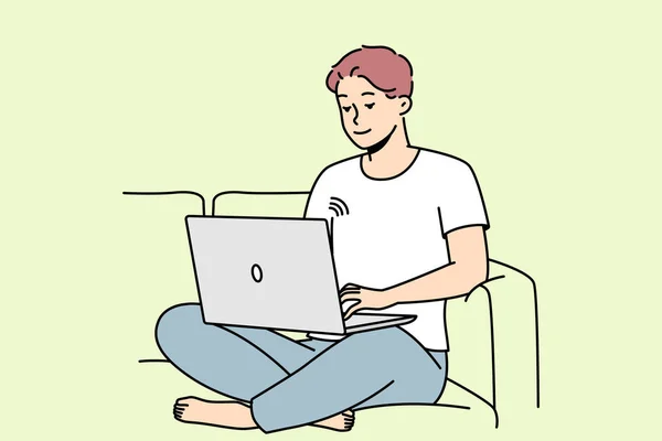 微笑的家伙坐在沙发上 用无线网络在笔记本电脑上工作 快乐的年轻人在沙发上放松 在电脑上浏览互联网 矢量说明 — 图库矢量图片