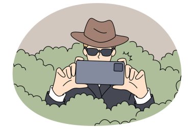 Güneş gözlüklü özel dedektif çalılıklarda saklanıp akıllı telefon kamerasıyla fotoğraf çekiyor. Casus ya da gizli ajan cep telefonuyla suç çözme ya da tespit etme ile fotoğraf çekiyor. Vektör illüstrasyonları.