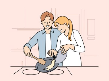 Evli çift pazar sabahı kahvaltı hazırlar ve sevdikleriyle iletişim kurmaktan mutluluk duyarlar. Mutlu bir çift kadın ve erkek krep ya da omlet pişiriyor.