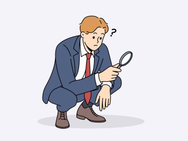 Büyüteçle çömelmiş bir işadamı analistin ya da denetçinin işlerini yapıyor. Takım elbiseli adam şirketteki finansal sorunların nedenlerini bağımsız olarak araştırıyor.