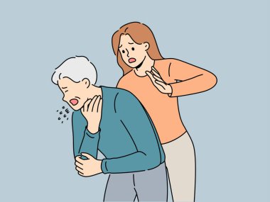 Kadın, solunum yolu tıkanıklığı nedeniyle yardıma ihtiyacı olan yaşlı adamı boğmak için Heimlich manevrası yapıyor. Hasta insan yemek yerken boğuldu ve öksürdü. Heimlich manevrası yapmaya hazır bir kızın yanında duruyordu.