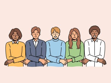 Çok ırklı öğrencilerden oluşan bir ekip el ele tutuşuyor ve üniversite öğrencileri arasında birlik veya ihtilaf eksikliği gösteriyor. Çeşitli öğrencilerden oluşan bir ekip takım oluşturma ve güven oluşturma etkinliğine katılıyor