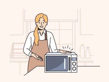 Kadın aşçı soğuk yemek ve içecekler ısıtmak için yeni mikrodalga fırın gösteriyor. Kız şef kafe ya da yemek odasının mutfağında duruyor ve sıcak öğle yemeği işlemleri için mikrodalga fırına el atıyor.