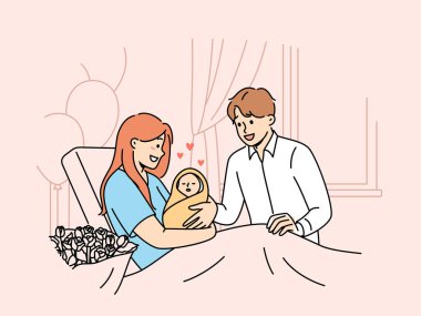 Bebeği olan bir anne hastanede koltukta oturup bebeğini mutlu babaya gösterir. Gülümseyen evli çift ilk kez ebeveyn oldu. Battaniyeye sarılı uyuyan bebeğe hayranlık duyuyorlar.