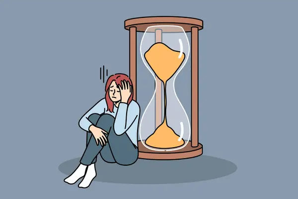 女性は 大きな時計の近くに座っている厳しい締め切りを悲しく思っており スキルが生産性を向上させる必要がある 生産性の欠如は 時間通りに完全な作業ができないため 少女のストレスを引き起こします ロイヤリティフリーのストックイラスト
