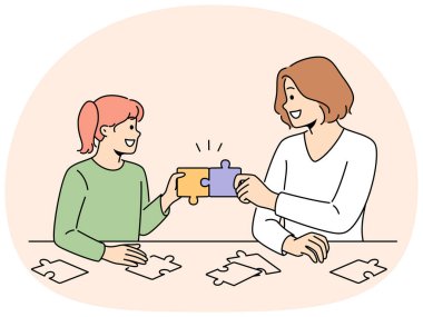 Gülümseyen anne ve kızı bulmacaları birlikte çözer. Mutlu anne ve kız çocuk yapboz parçaları masada oturarak komik bir oyun oynuyorlar. Vektör illüstrasyonu.