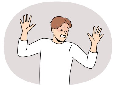 Korkmuş adam teslim olarak ellerini kaldırır ve itaat ettiğini gösterir ve direnmeyi reddeder. Psikolojik travma kaynaklı fobi yüzünden panik atak geçiren korkmuş bir adam.