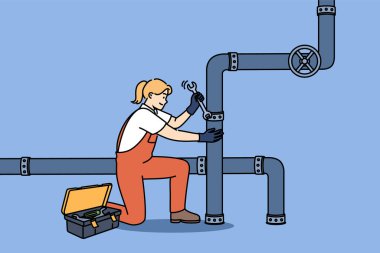 Woman plumber repairs pipes in factory, using wrench to fix crack in industrial pipeline. Girl in overalls works as plumber, easily doing men job and enjoying difficult profession. clipart