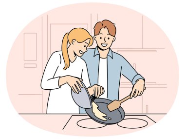 Evli çift pazar sabahı kahvaltı hazırlar ve sevdikleriyle iletişim kurmaktan mutluluk duyarlar. Mutlu bir çift kadın ve erkek krep ya da omlet pişiriyor.