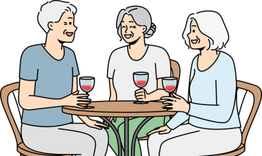 Gülümseyen yaşlı insanlar kafede oturup şarap içerler.