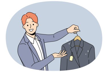 Man holds new jacket with tag offering to buy business clothes for managers or clerks. Guy works as salesman or dry cleaning employee and looks at screen with smile, giving client jacket on hanger clipart