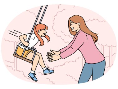 Anne kızını salıncakta sallıyor ve temiz havada çocukla rahatlamayı seviyor. Küçük kızı olan mutlu bir aile yaz tatili ya da hafta sonu salıncakta sallanan bir kadın.