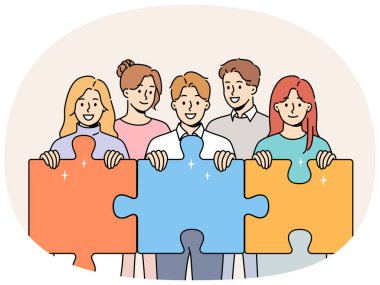 Dost canlısı erkek ve kadınlardan oluşan ekip, iş sorunlarını çözmek için birlikte çalışmayı sembolize eden dev yapboz parçaları tutuyor. Gülümseyen iş adamları şirket gelirini artırmak için takım çalışması yapıyorlar.