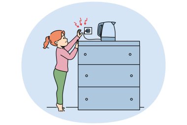 Küçük kız bir soket elektrikli su ısıtıcısına uzanır, sıcak su tarafından yanma ya da elektrik şoku alma riskini göze alır. Çocuk elektrikli aletlere dokunarak güvenlik kurallarını ihlal ediyor.