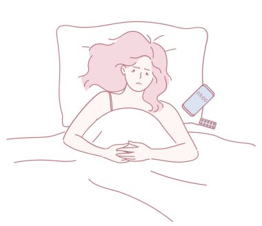 Bir kadın yatakta uykusuzluk zemininde telefonuna bakarak huzursuz bir şekilde uzanıyor..