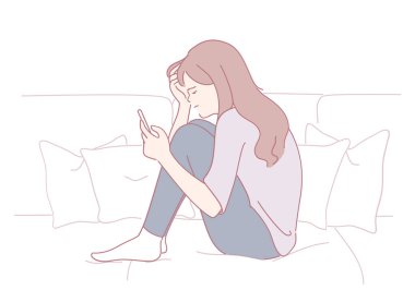 Genç bir kadın rahat bir koltukta oturuyor, akıllı telefonuyla derin düşüncelere dalmış, karışık duygular yaşıyor.