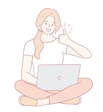 Neşeli genç bir kadın dizüstü bilgisayarıyla kucağında oturup onaylama ve pozitiflik işareti veriyor.