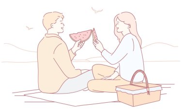 Hoş ve romantik bir piknik sahnesi güzel sahil kenarında neşeyle karpuz paylaşan bir çifti gösteriyor.