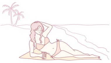 Güneşli bir sahilde, palmiye ağaçları ve dalgalanan dalgaların sesiyle çevrili bir kadın soğuk bir içecekten hoşlanır.