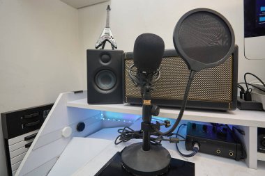 Yayıncının çalışma istasyonu mikrofon, anti-pop filtresi ve diğer stüdyo ekipmanları.