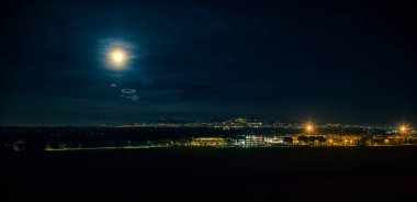 Arka planda Castelli Romani 'nin ışıkları olan yaz dolunayı.