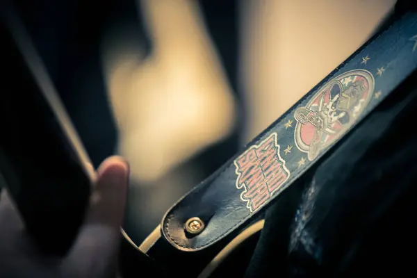 Güneyli rock gitaristinin elektro gitar kayışı. Üzerinde Lynryd Skynyrd yazıları ve logosu var.