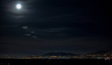 Arka planda Castelli Romani 'nin ışıkları olan yaz dolunayı.