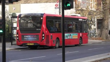 Londra, İngiltere - 2022.12.02: Batı Londra 'da işlek yoldaki otobüs durağından ayrılan Double Decker otobüsünün yavaş çekim görüntüleri