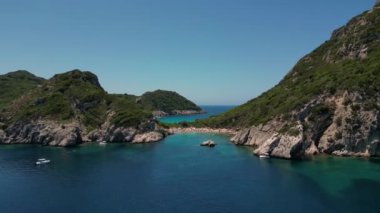 Korfu Adası, Yunanistan - 2023.07.01 - 09: Kavurucu bir yaz gününün büyüleyici turkuaz suları arasında kalabalık Porto Timoni Sahili, Korfu Adası 'nda dinlenen sayısız kişi