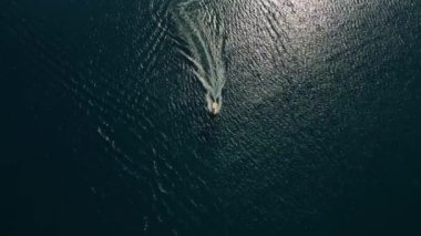 Yunanistan 'ın Corfu adası - 2023.07.01 - 09: Yunan adalarının sakin denizinin çarpıcı turkuaz sularında küçük bir motorlu tekne seyahat ediyor