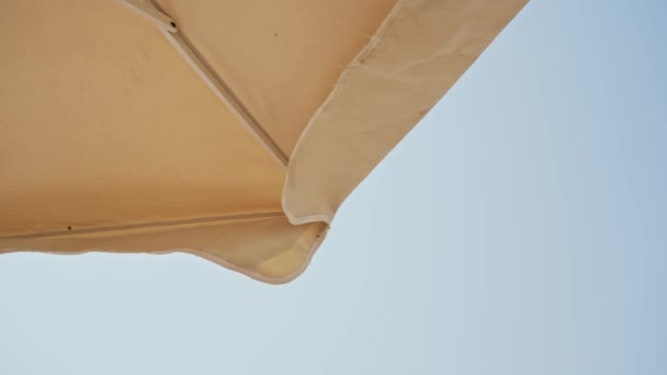 コルフ島 ギリシャ 2023 風とビーチで晴れた日の映像が陽の傘の縁をうまく錆びている — ストック動画