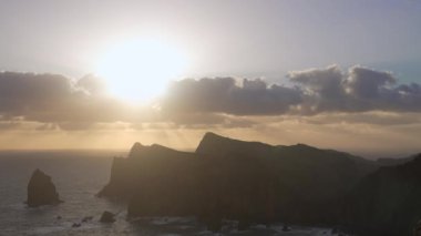 Madeira, Portekiz - 2023.04.04 - 09: Bulutlar, kayalıklar ve mavi sularla dolu rüzgarlı bir günde Miradouro da Ponta do Rosto 'da gün doğumunun güzel manzarası