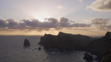 Madeira, Portekiz - 2023.04.04 - 09: Bulutlar, kayalıklar ve mavi sularla dolu rüzgarlı bir günde Miradouro da Ponta do Rosto 'da gün doğumunun güzel manzarası