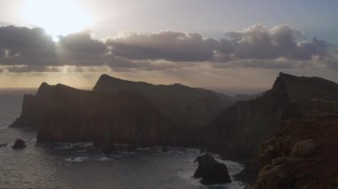 Madeira, Portekiz - 2023.04.04 - 09: Bulutlar, kayalıklar ve mavi sularla dolu rüzgarlı bir günde Miradouro da Ponta do Rosto 'da gün doğumunun güzel manzarası