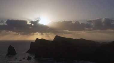 Madeira, Portekiz - 2023.04.04 - 09: Bulutlar, kayalıklar ve mavi sularla dolu rüzgarlı bir günde Miradouro da Ponta do Rosto 'da gün doğumunun güzel manzarası