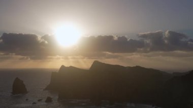 Madeira, Portekiz - 2023.04.04 - 09: Bulutlar, kayalıklar ve mavi sularla dolu rüzgarlı bir günde Miradouro da Ponta do Rosto 'da gün doğumunun güzel manzarası