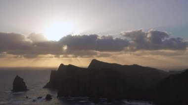 Madeira, Portekiz - 2023.04.04 - 09: Bulutlar, kayalıklar ve mavi sularla dolu rüzgarlı bir günde Miradouro da Ponta do Rosto 'da gün doğumunun güzel manzarası