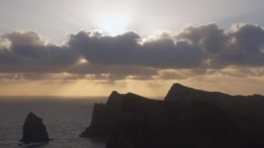 Madeira, Portekiz - 2023.04.04 - 09: Bulutlar, kayalıklar ve mavi sularla dolu rüzgarlı bir günde Miradouro da Ponta do Rosto 'da gün doğumunun güzel manzarası