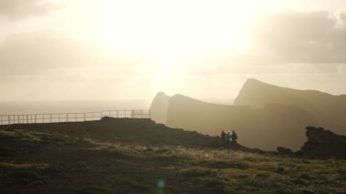 Madeira, Portekiz - 2023.04.04 - 09: Bulutlar, kayalıklar ve mavi sularla dolu rüzgarlı bir günde Miradouro da Ponta do Rosto 'da gün doğumunun güzel manzarası