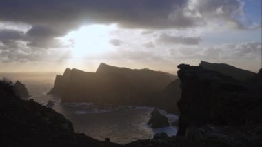 Madeira, Portekiz - 2023.04.04 - 09: Bulutlar, kayalıklar ve mavi sularla dolu rüzgarlı bir günde Miradouro da Ponta do Rosto 'da gün doğumunun güzel manzarası