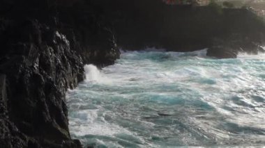 Madeira, Portekiz - 2023.04.04 - 09: Bulutlu bir günde Madeira 'nın kuzey kıyısında dalgaların çarpışması