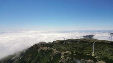 Madeira, Portekiz - 2023.04.04 - 09: Güneşli bir günde dağın tepesindeki rüzgâr çiftliklerinin alçak bulutları Lombo do Mouro perspektifindeki güzel hava aracı görüntüleri