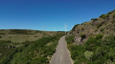 Madeira, Portekiz - 2023.04.04 - 09: Güneşli bir günde dağın tepesindeki, Miradouro Molinas 'ta alçak bulutlu rüzgar çiftliklerinin güzel hava aracı görüntüleri