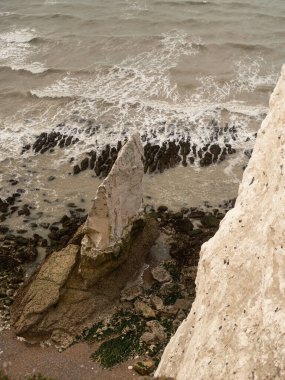 Seaford - Eastbourne - İngiltere - 2024.08.25: Güneşli bir günde okyanus dalgalarının çarptığı Seaford uçurumlarının nefes kesici manzarası, doğal güzellik ve sükuneti gözler önüne seriyor.