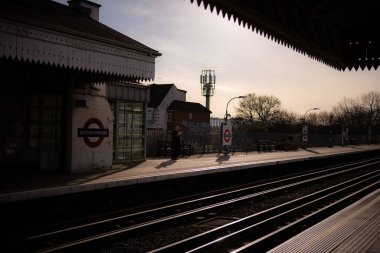 Güneşli kış gününde Boston Malikânesi Piccadilly metro istasyonunda kitap okuyan bir adam..