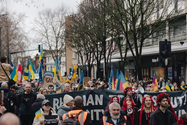 Londra - İngiltere - 2025.02.22 Ukrayna 'nın tam ölçekli işgalinin üçüncü yıldönümü münasebetiyle düzenlenen gösteride bayrakları ve bayrakları olan insanlar