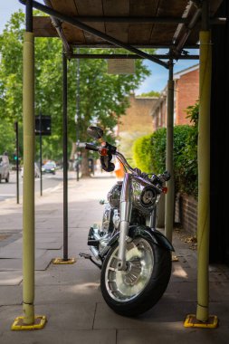 Chiswick, Londra, İngiltere 2025.06.19 Sunny caddesinde arka planda Saffron vejetaryen organik marketi olan parlak mavi orman kiralık bisikletleri, Batı Londra 'da kentsel bisiklet ve sürdürülebilir ulaşımı yakalıyor..